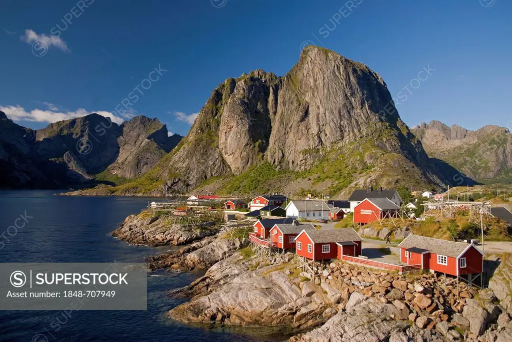 Typical red rorbuer huts, rorbu, at the coast of the Norwegian Sea, mountains at back, Hamnøy, island of Moskenesøy, Moskenesoy, Lofoten archipelago, ...