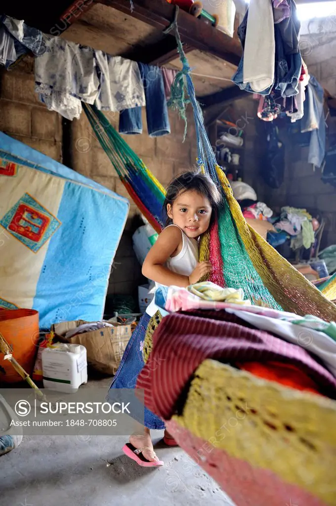 Girl standing in a simple and disorderly house, El Angel, Bajo Lempa, El Salvador, Central America, Latin America
