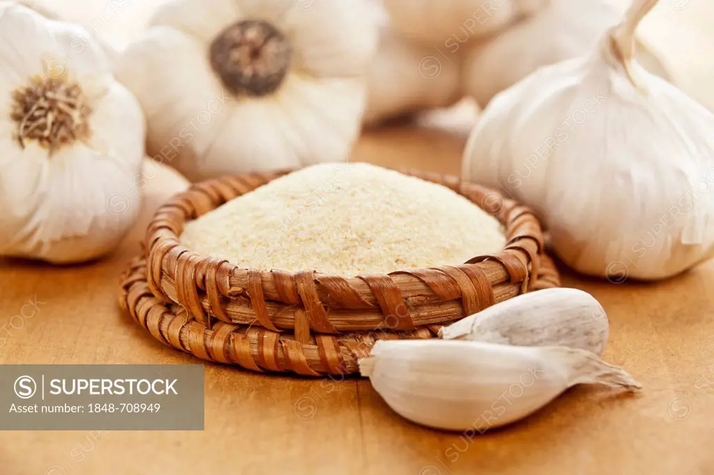 Garlic and garlic powder in a bowl on a wooden board