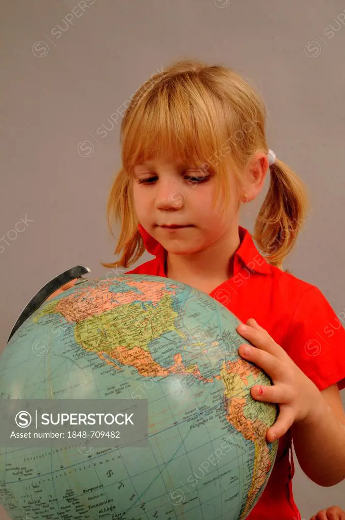 Little girl, 5 years, looking at a globe