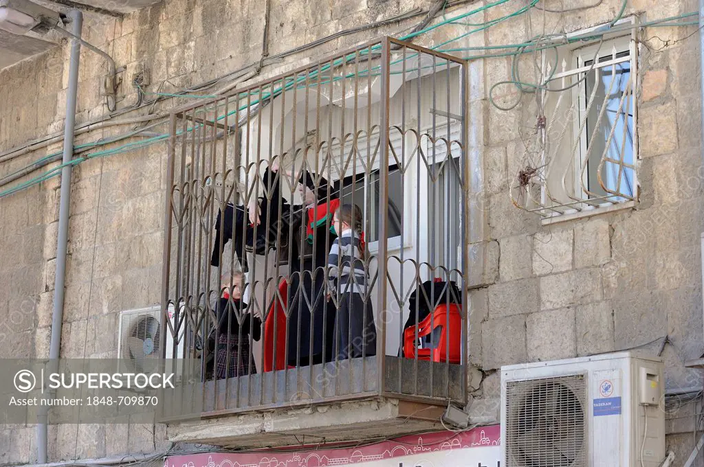 Barred balcony with woman and children and air-conditioning, Me'a She'arim district, Jerusalem, Israel, Middle East, Asia