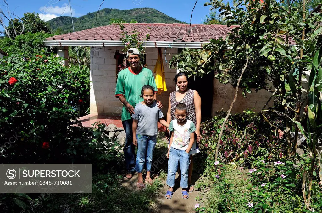 Family with two children in front of their house that was made available to them by an aid organisation after the 2011 earthquake, community of Cerro ...