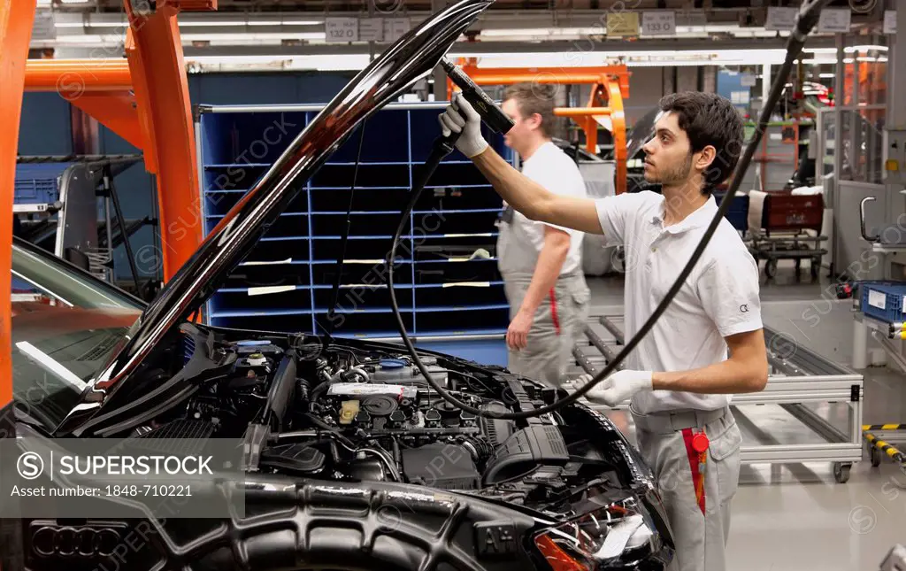 An Audi employee installing hooks on an Audi A4 Sedan, assembly line, Audi plant, Ingolstadt, Bavaria, Germany, Europe