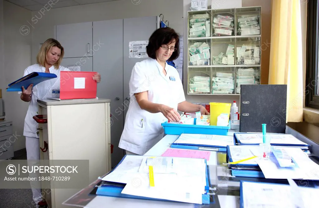 Nurses preparing the documents and medicine for patients in the nurse's station of a hospital