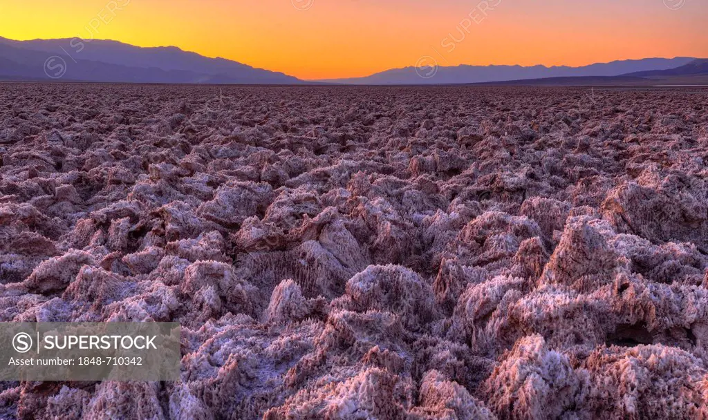 Spectacular lighting after sunset, salt crust on the Devil's Golf Course, Panamint Range, Black Mountains, Death Valley National Park, Mojave Desert, ...
