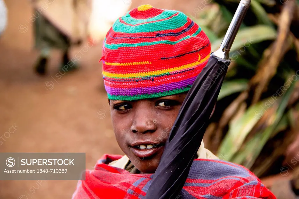 Boy with knitted hat and umbrella, in Lalibela, Ethiopia, Africa