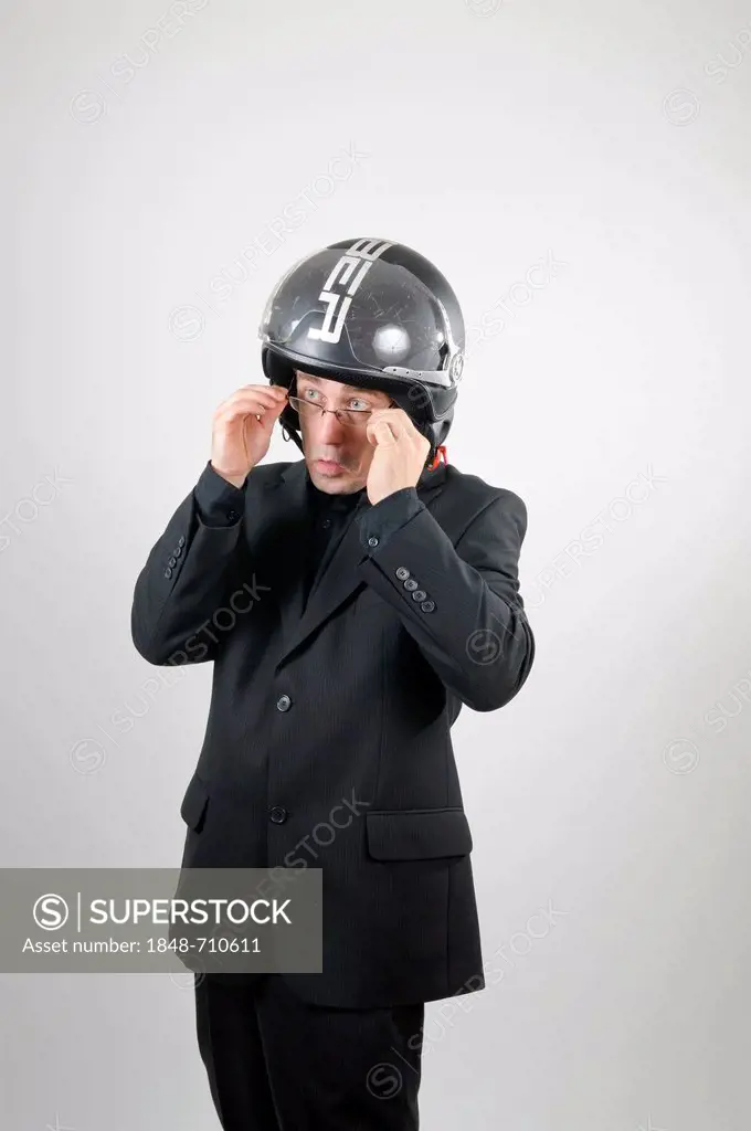 Businessman wearing a black suit and a motorcycle helmet