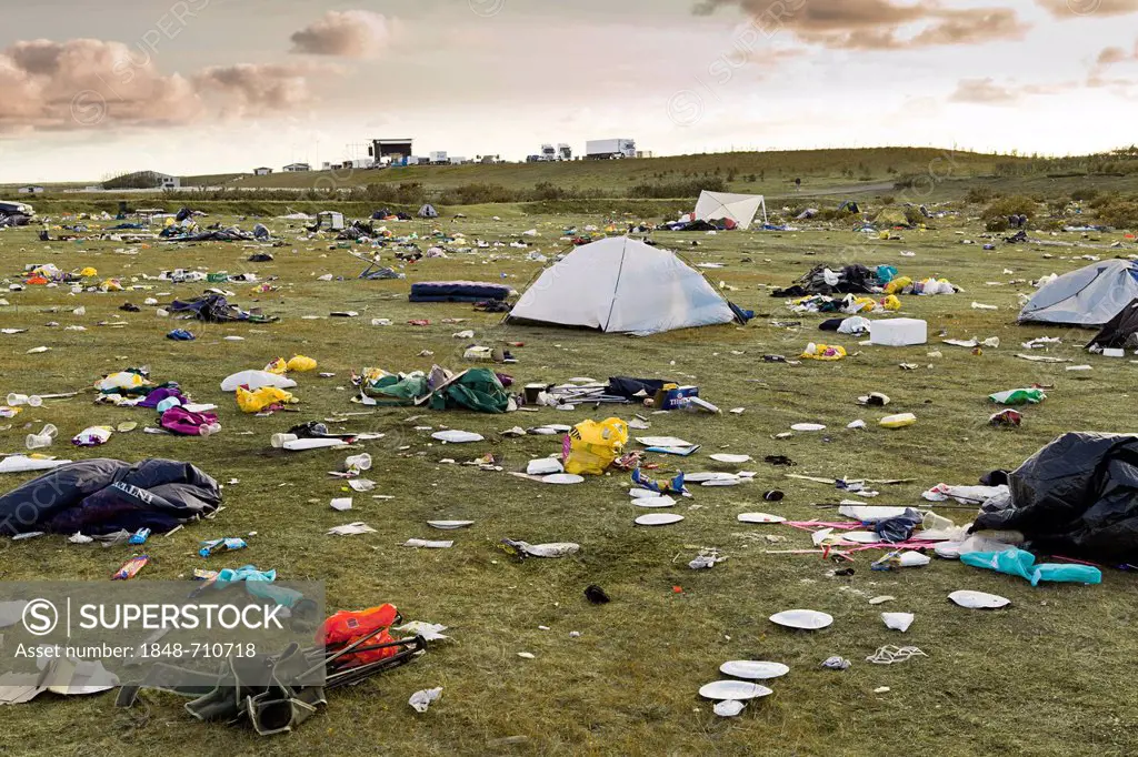 Meadow full of garbage, waste, destroyed tents and broken camping equipment after a rock concert for young people on the outskirts of Hella in the sou...