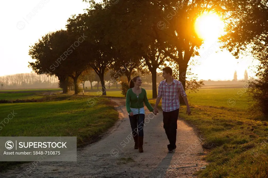 Young couple taking a walk outdoors, in nature