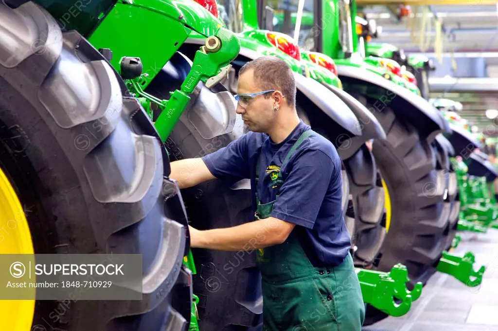 Wheels are mounted in the tractor production section at the European headquarters of the American agricultural machinery manufacturer John Deere, Deer...