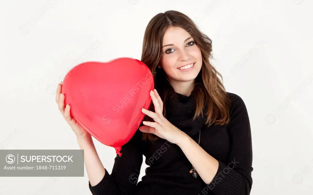 Young woman holding a balloon heart