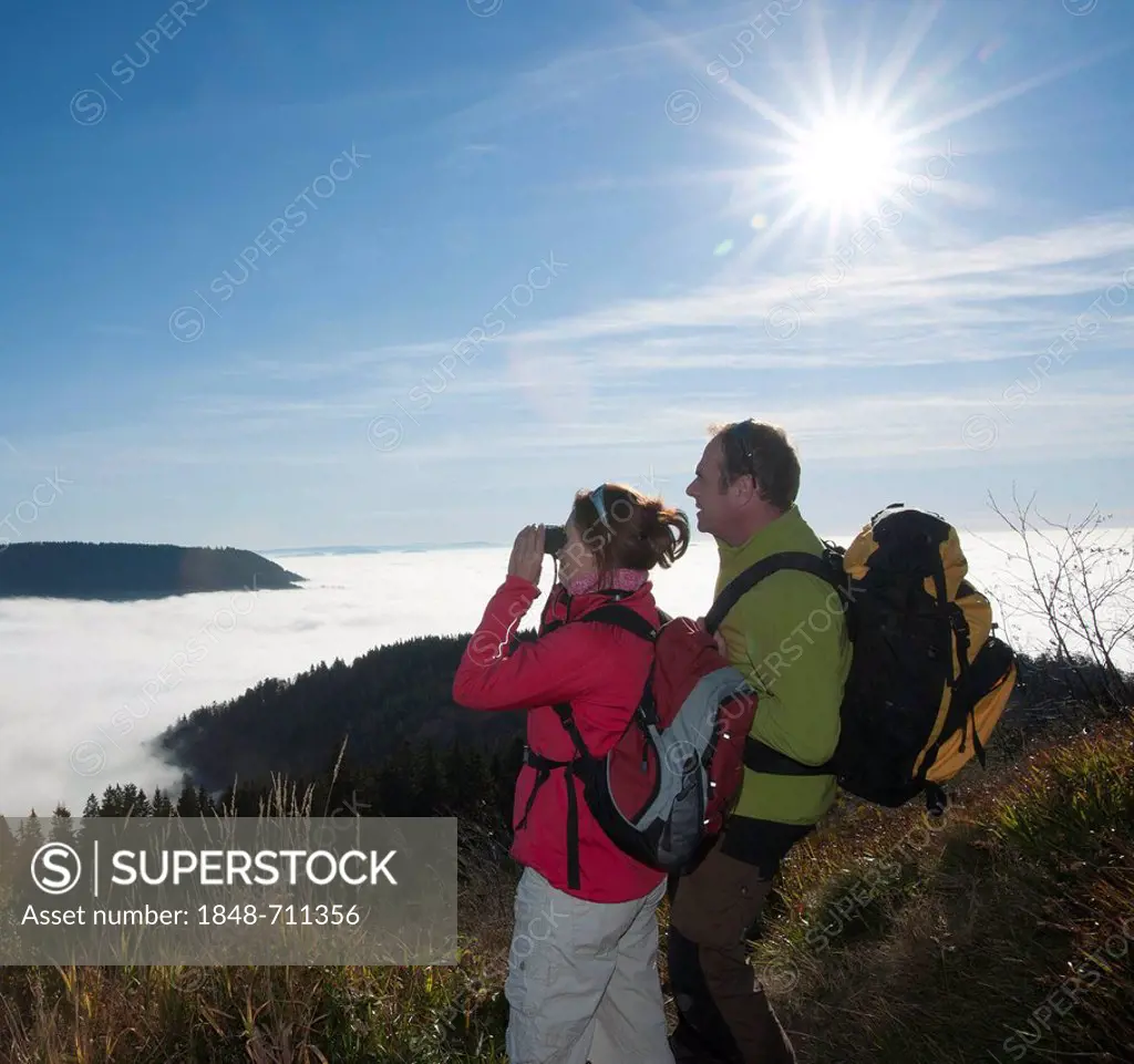 Couple on a hiking trip looking at a fog shrouded valley, Black Forest, Baden-Wuerttemberg, Germany, Europe