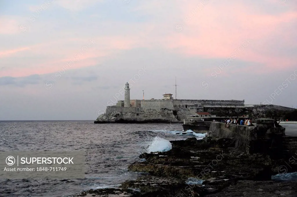 On the Malecon, Avenida de Antonio Maceo, a boulevard in the city center of Havana, Centro Habana, with the lighthouse and fort at the harbour entranc...