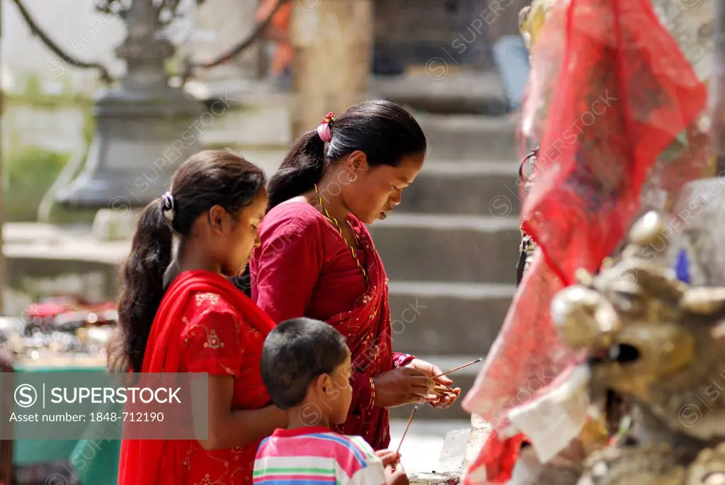 Praying women with child, Swayambhunath temple, Kathmandu, Nepal, Asia