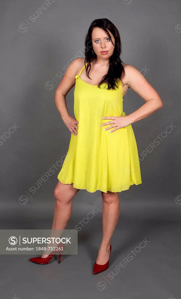 Young woman wearing a yellow dress and red shoes
