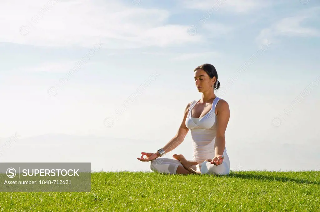 Young woman practising Hatha yoga outdoors, showing the pose padmasana, lotus pose, Nove Mesto, Okres Teplice, Czech Republic, Europe