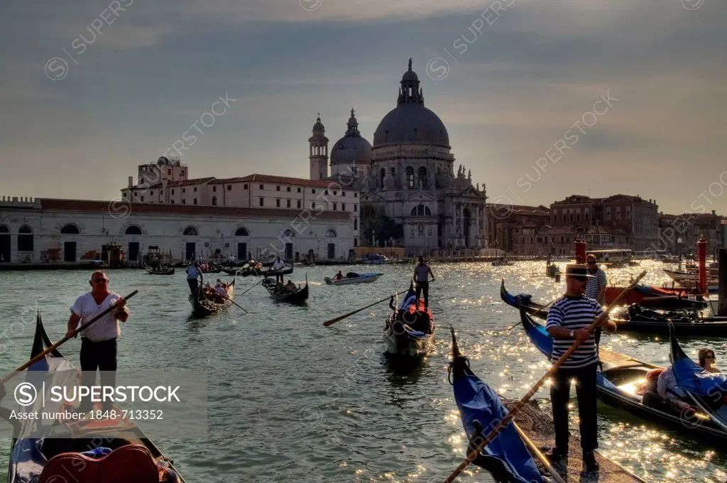 View from St. Mark's Square towards the Chiesa di Santa Maria della Salute Church in the evening light, with returning gondolas on Bacino die San Marc...