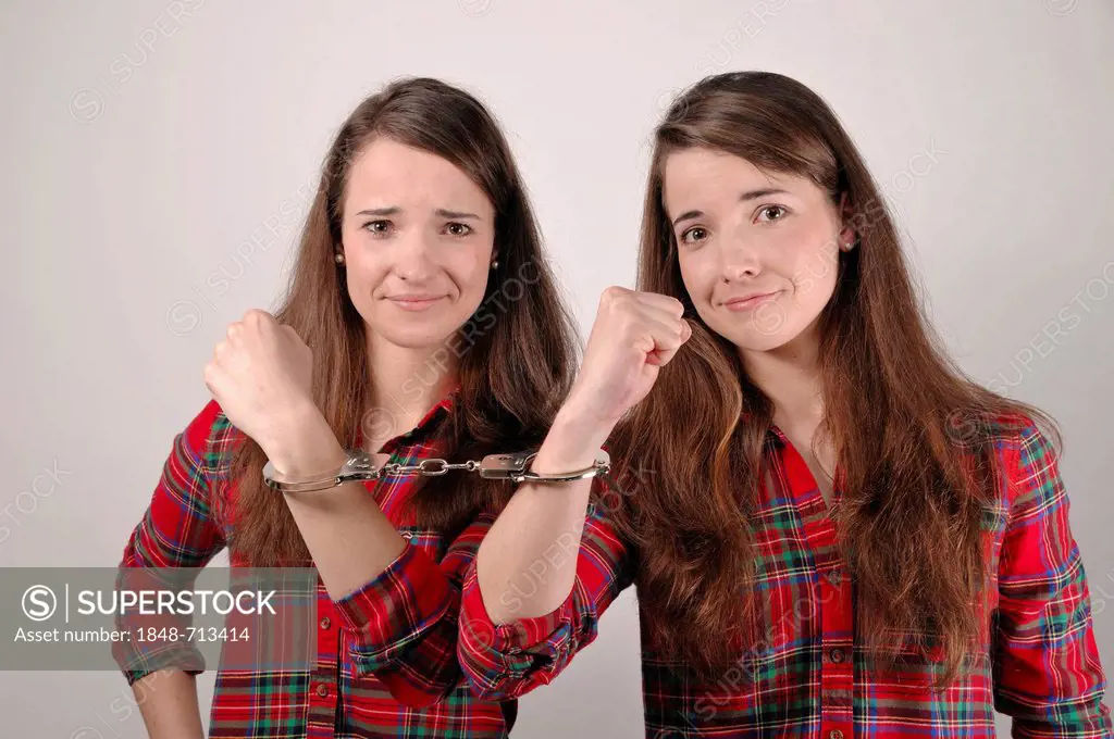 Twin sisters, chained together with handcuffs