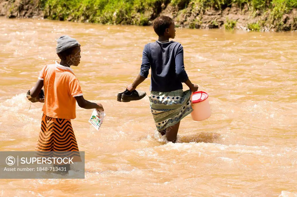 Young Basotho women wading through a river, Drakensberg, Kingdom of Lesotho, southern Africa