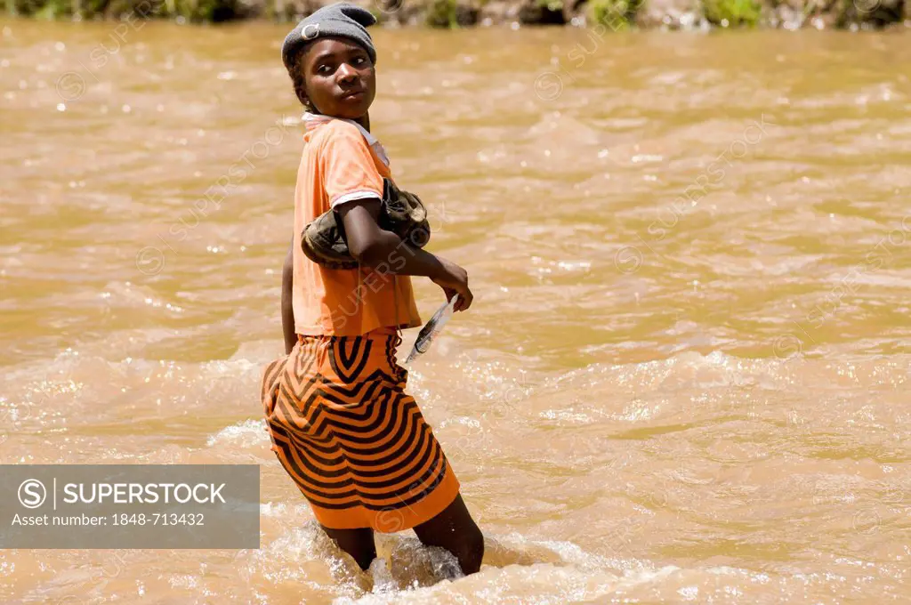Young Basotho woman wading through a river, Drakensberg, Kingdom of Lesotho, southern Africa