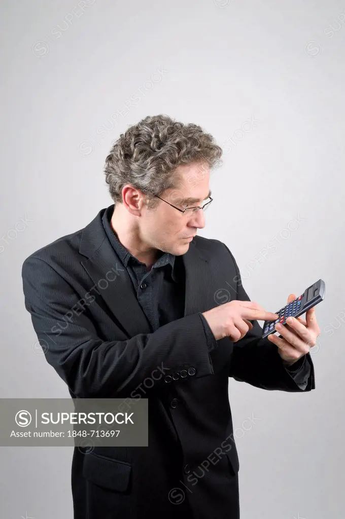 Businessman wearing a black suit holding a calculator