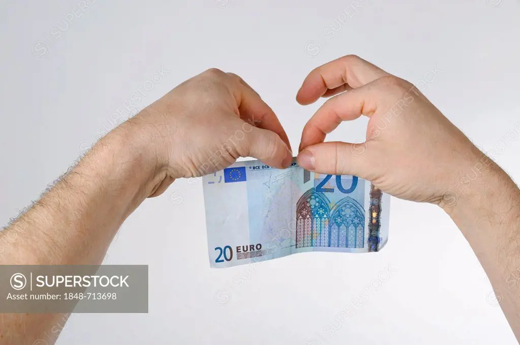 Hands ripping a 20-euro note