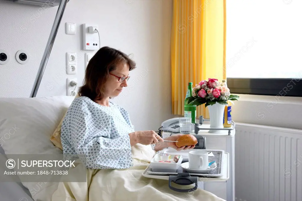 Patient lying in a hospital bed eating a meal, hospital