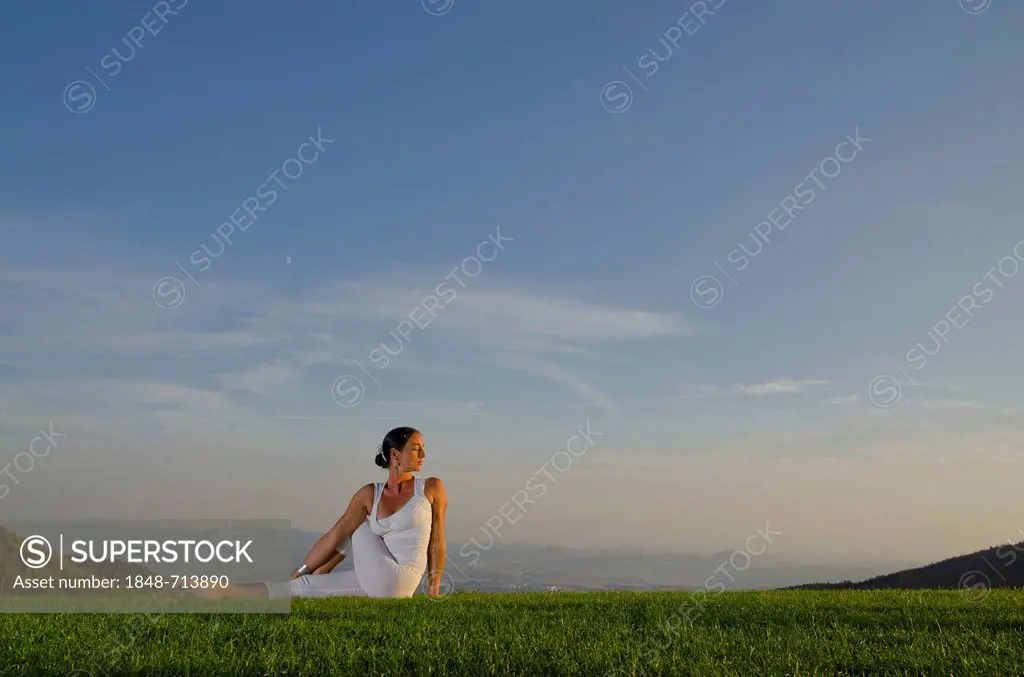 Young woman practising Hatha yoga outdoors, showing the pose ardha matsyendrasana, half spinal twist, Nove Mesto, Okres Teplice, Czech Republik, Europ...