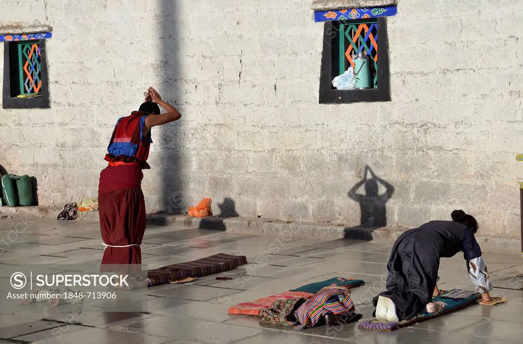 Tibetan Buddhism, Tibetan pilgrims and monks prostrating in front of Jokhang Temple, Barkhor, Lhasa, Tibet, China, Asia
