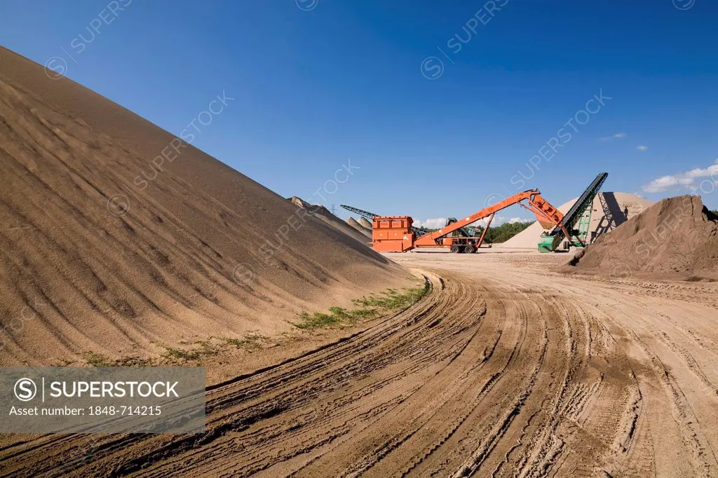 Mounds of sand and machinery in a commercial sandpit, Quebec, Canada