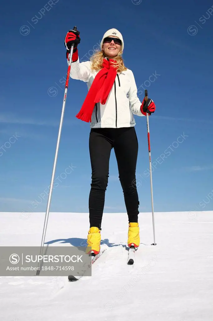Young woman, about 25 years, against a blue sky, cross-country skiing, near Masserberg, Thuringian Forest mountains, Thuringia, Germany, Europe