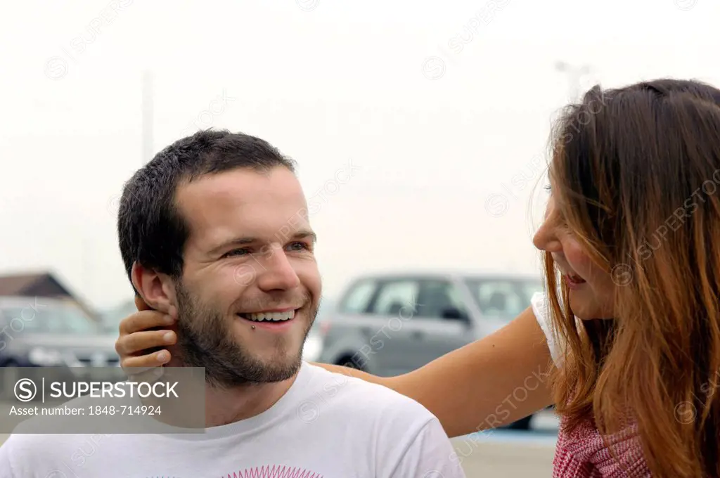 A young couple welcoming each other on a parking lot, EuroAirport Basel-Mulhouse-Freiburg, Switzerland, France, Europe, PublicGround