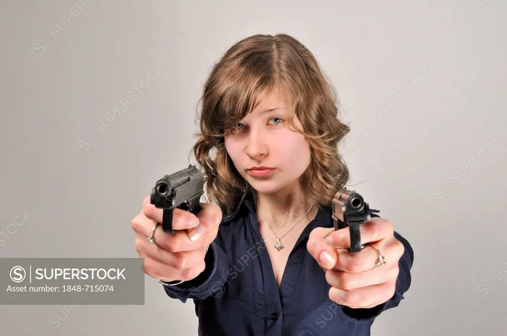 Young woman, 20, holding 2 pistols