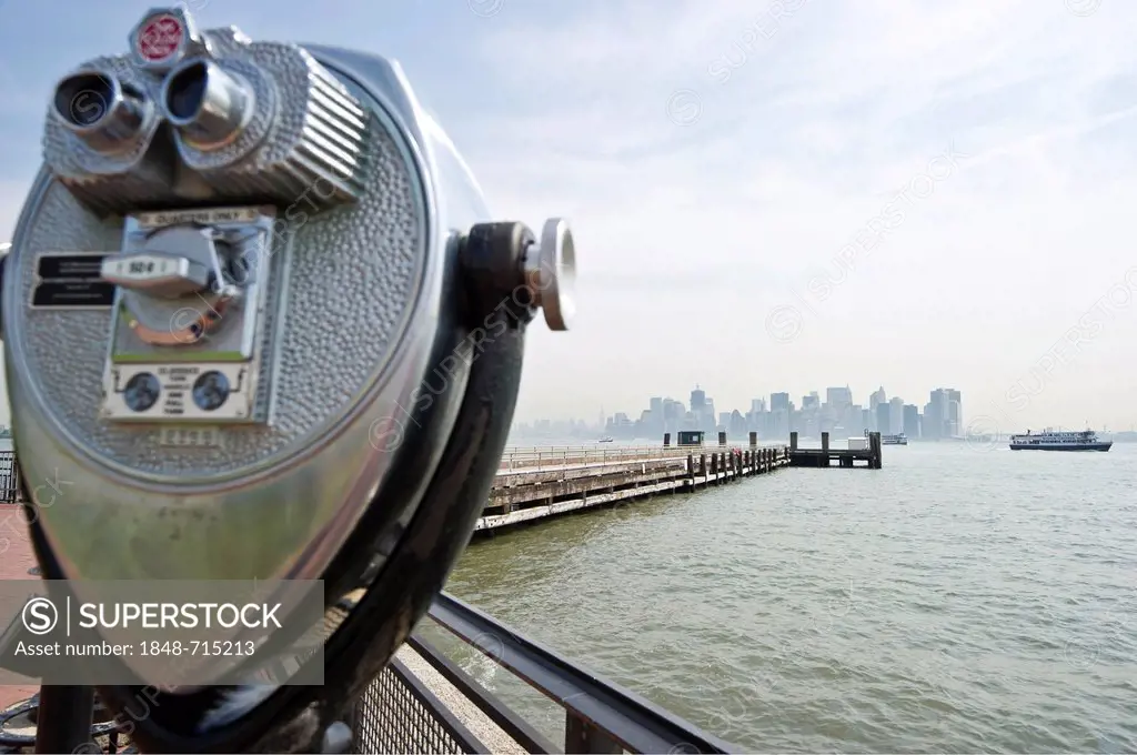 Telescope with a view of Liberty Island and the skyline of Manhattan, New York, USA