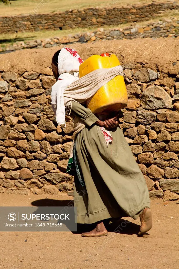Woman carrying water from Queen of Sheba's Swimming Pool, Aksum, Ethiopia, Africa