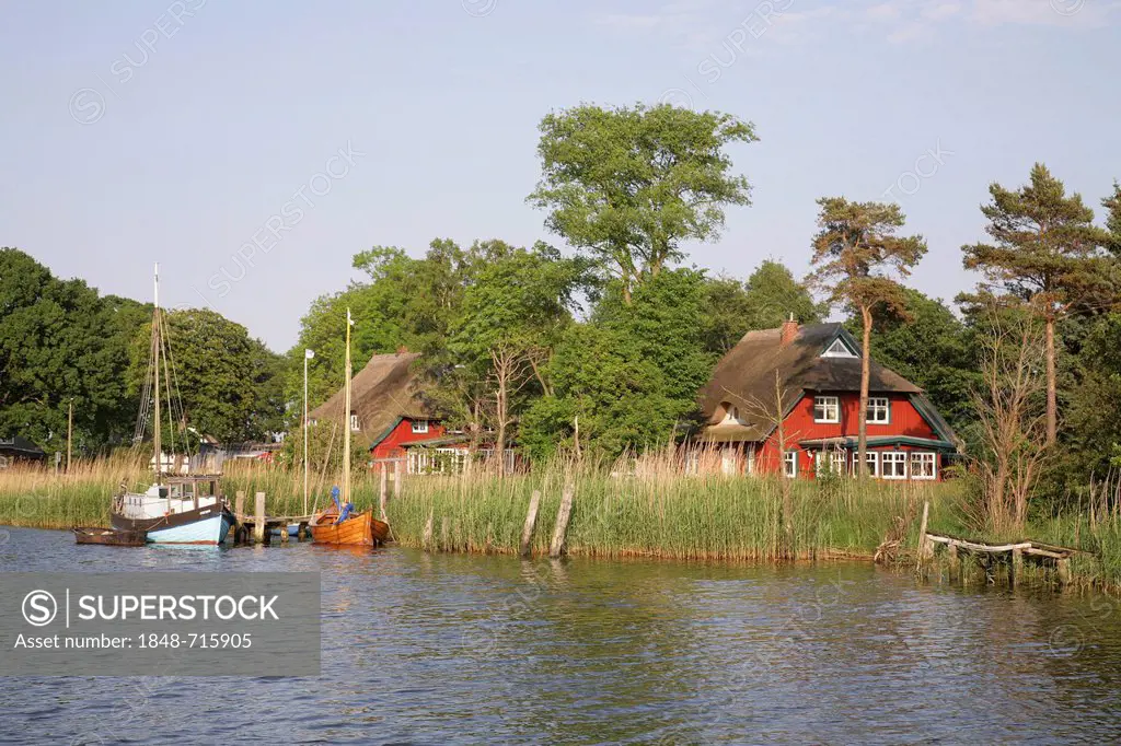 Boats and residential houses on the Prerow river near Prerow, Darss-Zingst, Western Pomerania Lagoon Area National Park, Mecklenburg-Western Pomerania...