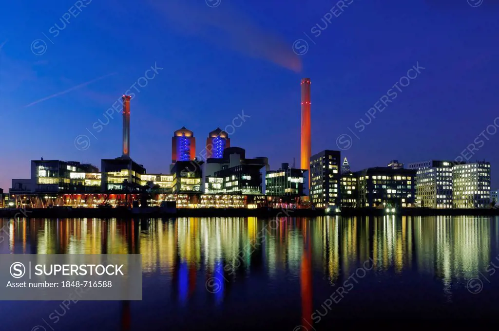 Illuminated Heizkraftwerk West, combined heat and power plant of Mainova AG, from the south bank of the Main river at dusk, Frankfurt am Main, Hesse, ...