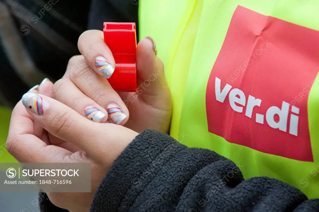 Woman holding a whistle wearing a high-viz jacked with the ver.di trade union logo, Germany, Europe