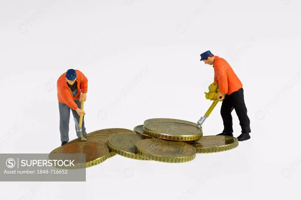 Miniature figures of construction workers with a pickaxe and a jackhammer working on a pile of euro coins, symbolic image for the pressure upon the Eu...