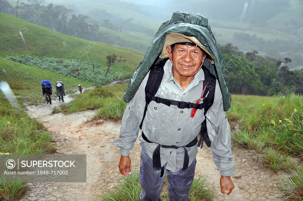 Mountaineer during a strenuous hike in the rain, Mount Roraima, table mountain, border triangle of Brazil, Venezuela and Guyana, South America