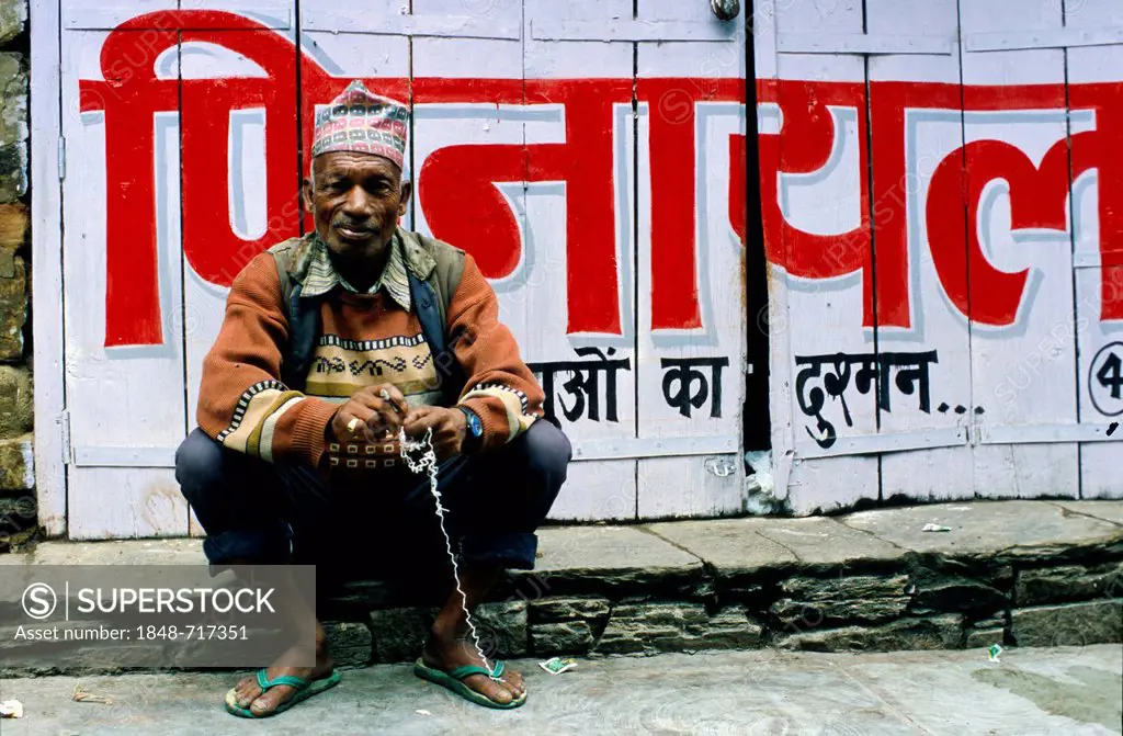 Man sitting on the sidewalk, Almora, Uttarakhand, formerly Uttaranchal, India, Asia
