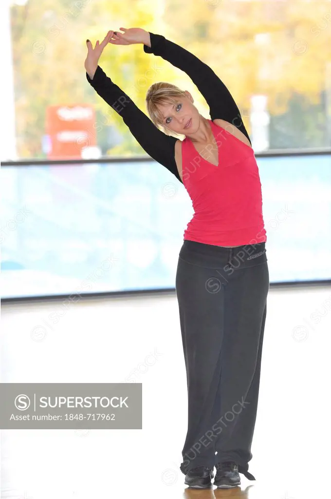 Young woman stretching, warming-up exercises, Haus des Sports, House of Sport, SpOrt, Stuttgart, Baden-Wuerttemberg, Germany, Europe