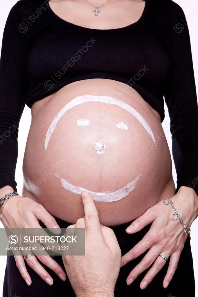Baby belly with painted smiley face