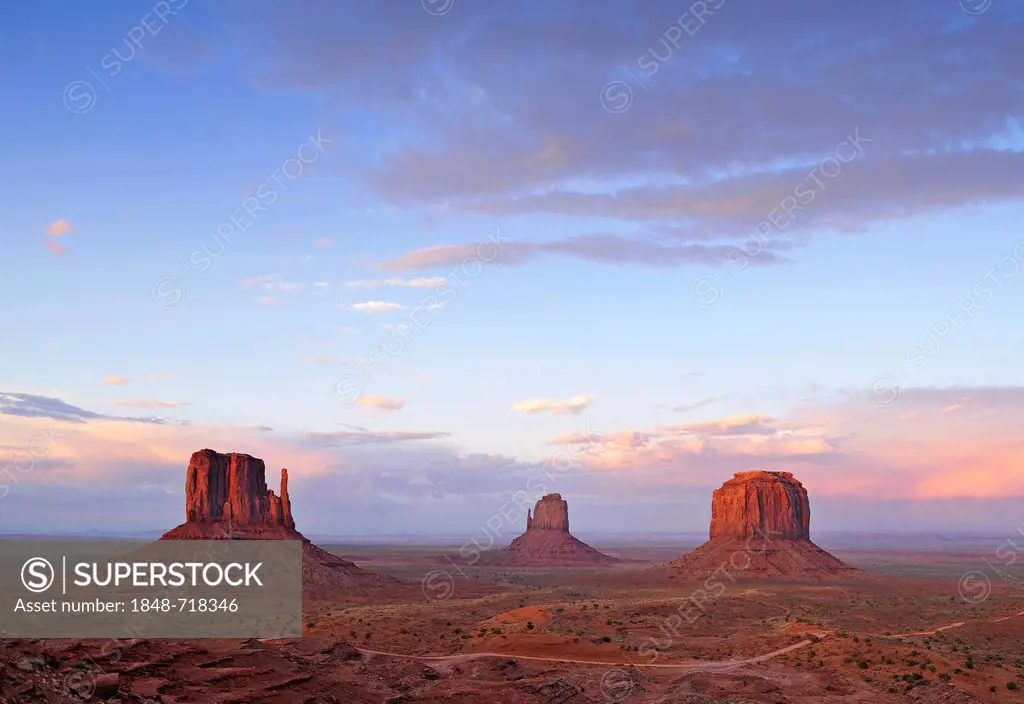 West Mitten Butte, East Mitten Butte and Merrick Butte table mountains and Scenic Drive in the evening light, Monument Valley, Navajo Tribal Park, Nav...