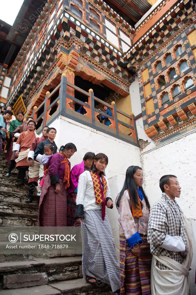 Tibetan Buddhist festival, people wearing the traditional Gho robe standing on a staircase in a queue, Rinpung Dzong Monastery and Fortress, courtyard...