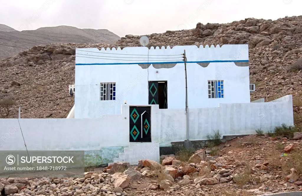 Typical residential building amidst the bare mountains of Ash Shab, Sultanate of Oman, Middle East, Southeast Asia, Asia