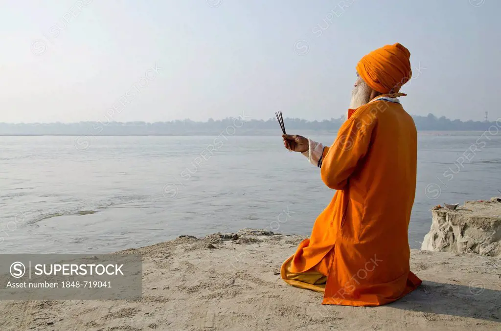 Sadhu, holy man, praying at Sangam, the confluence of the holy rivers Ganges, Yamuna and Saraswati, in Allahabad, Uttar Pradesh, India, Asia