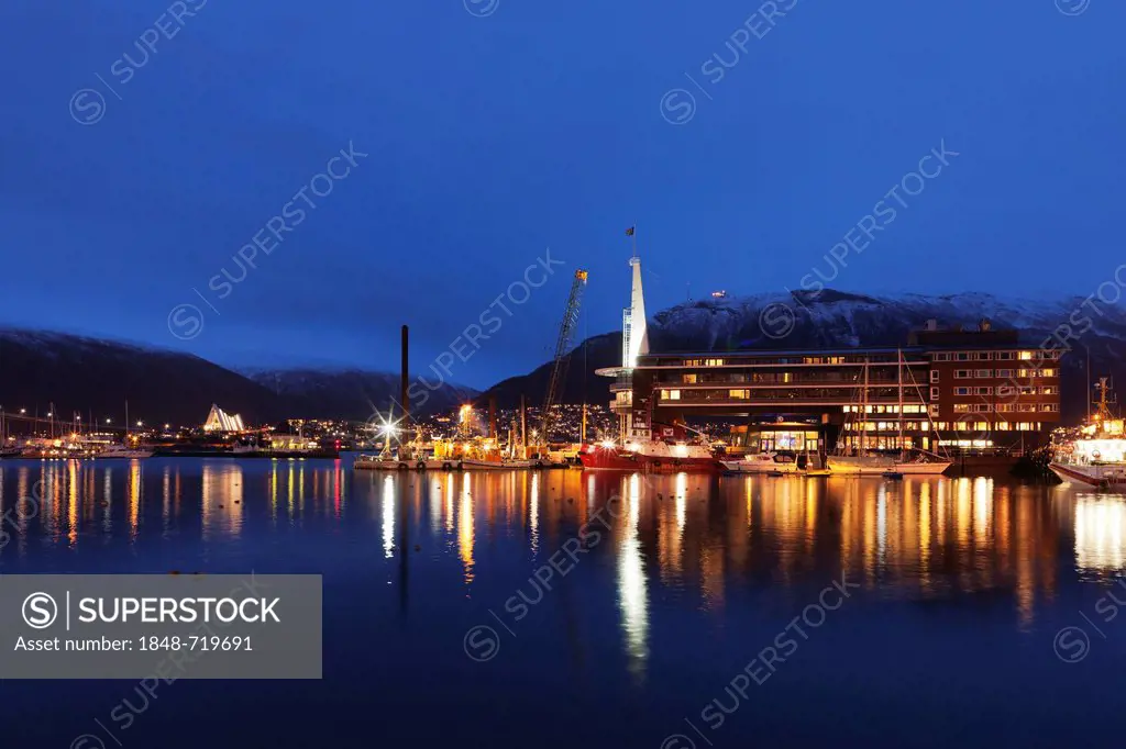 Night view of part of the harbour area of Tromsø, Tromso, showing the Ishavshotel and Tromsdalen Church, Arctic Cathedral or Ishavskatredalen, Norway,...