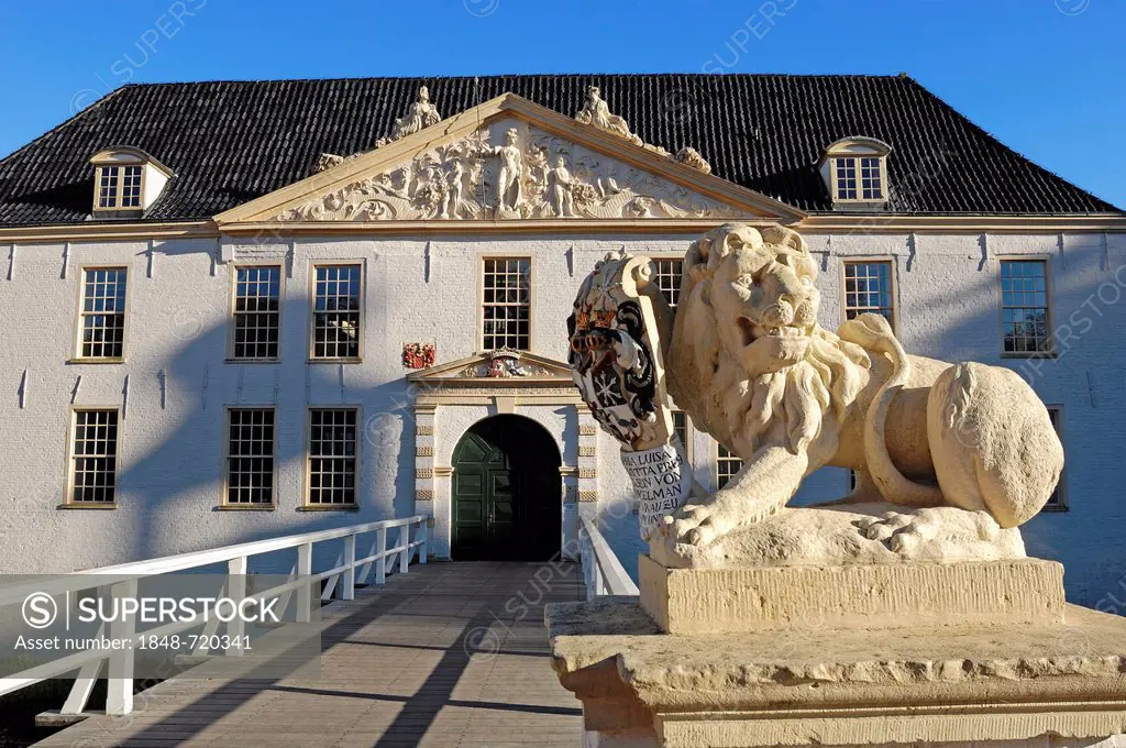 Lion sculpture and Norderburg Moated Castle, now a secondary school, Dornum, East Frisia, Lower Saxony, Germany, Europe