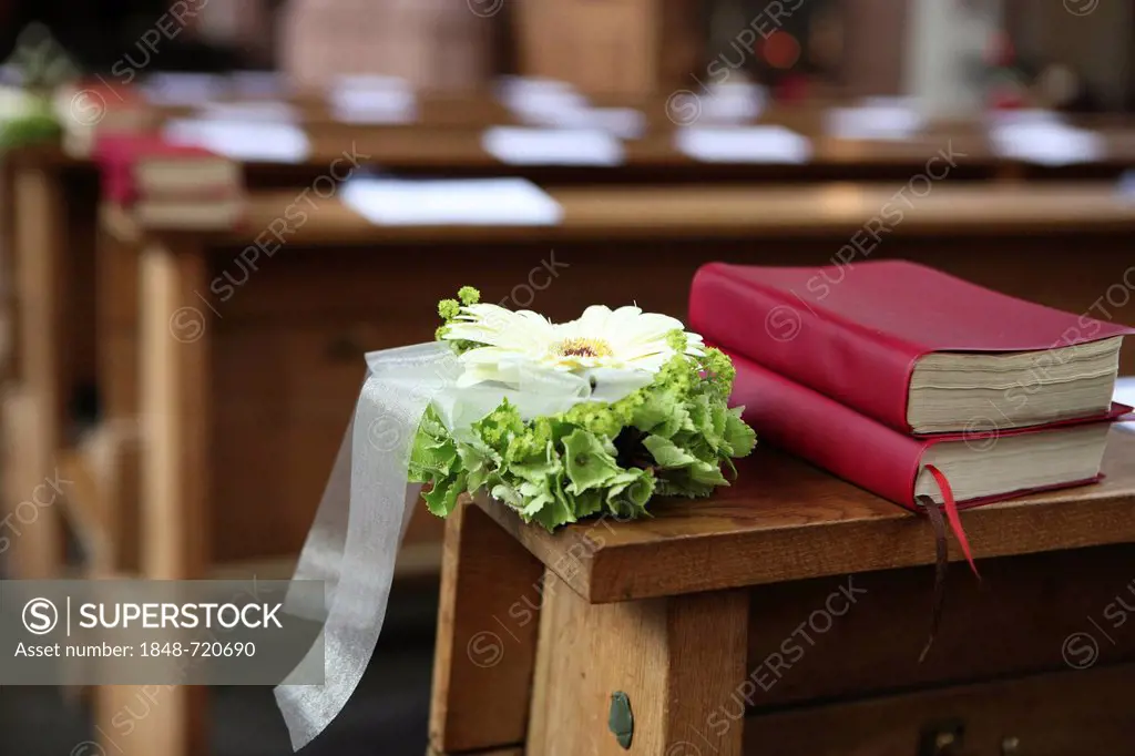 Floral arrangement and prayer hymnbooks, decorations in a church for a church wedding